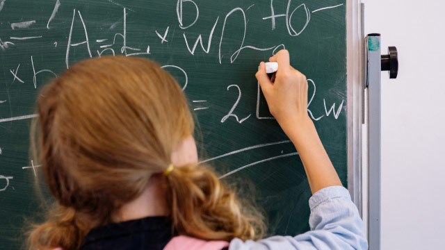 Child On The Blackboard Solving A Maths Equation