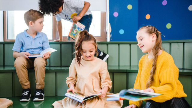 Children reading a book story for eachother