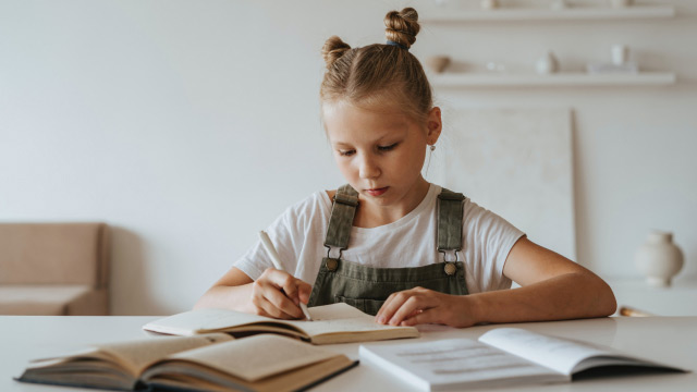 Young girl doing her homework on the desk